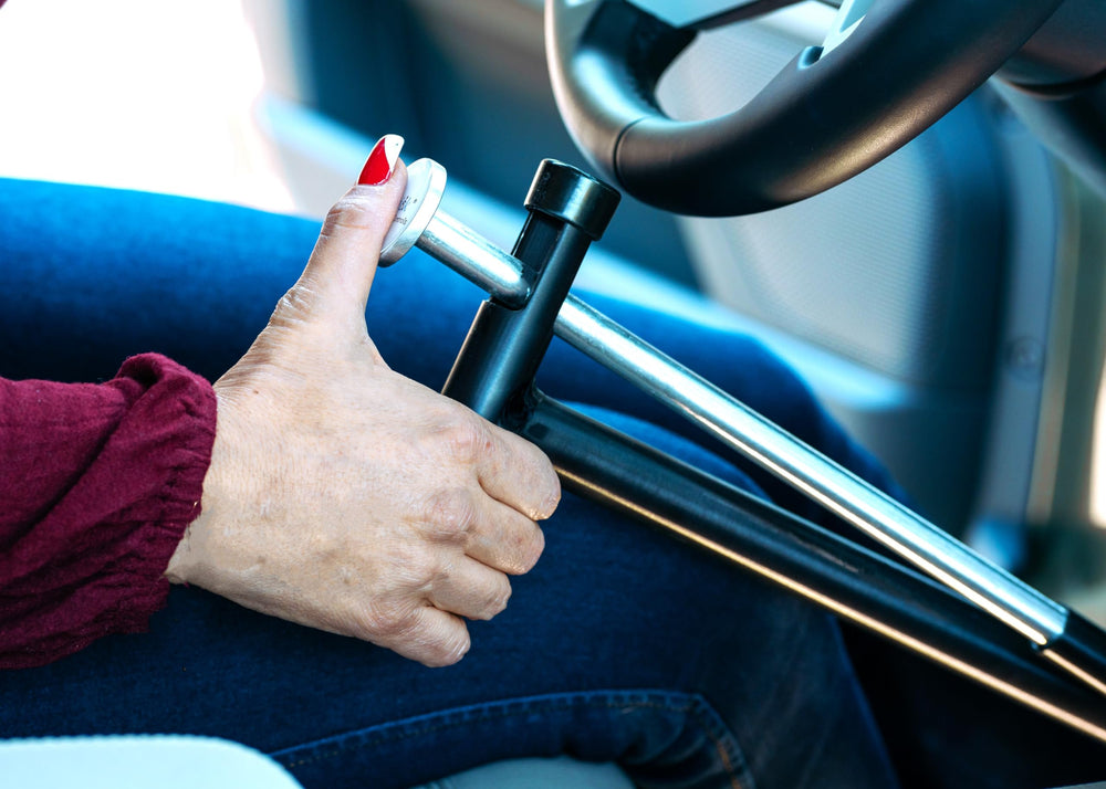 QuicStick size comparison next to steering wheel showing compact portability