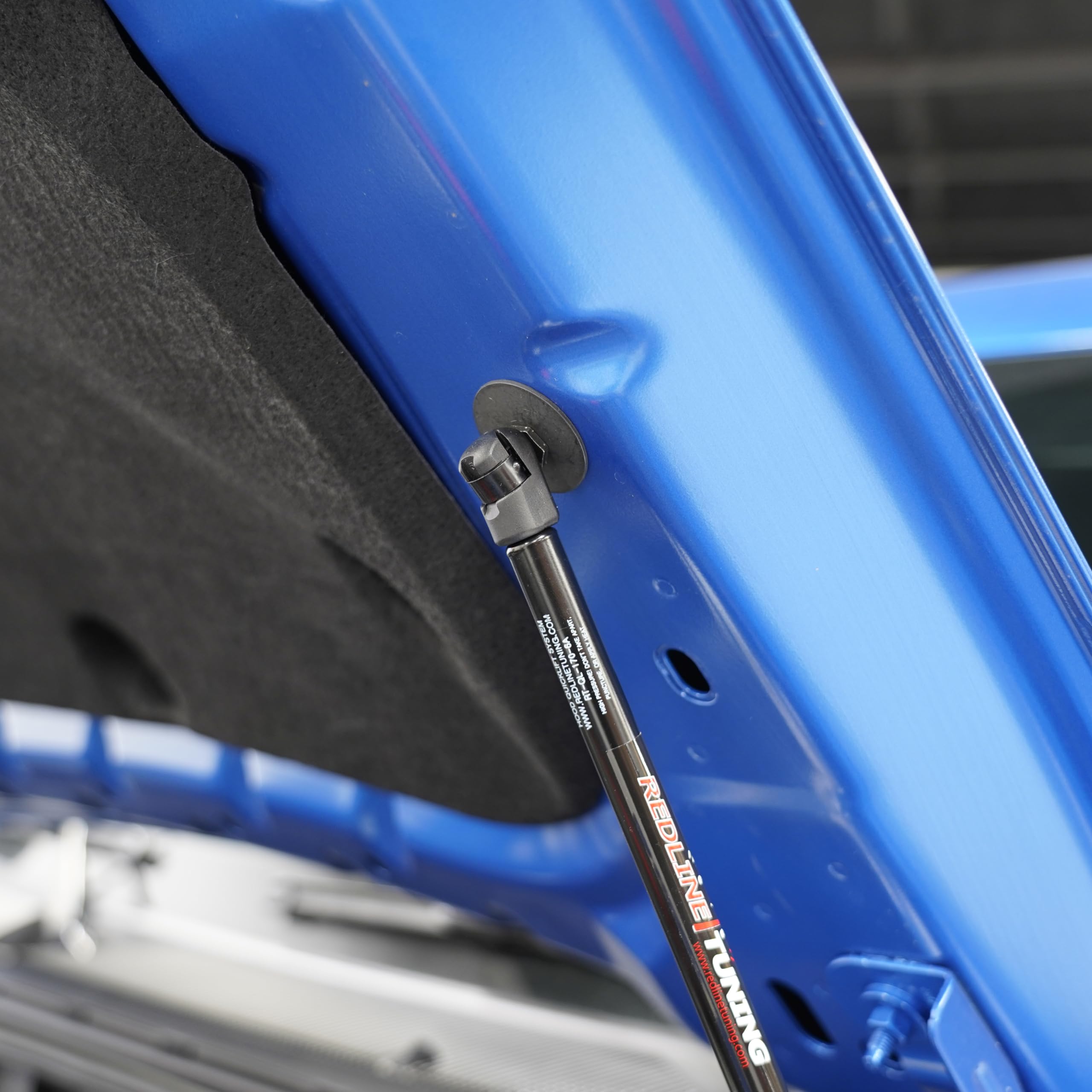 Redline Tuning gas spring close-up highlighting smooth lift and corrosion resistance