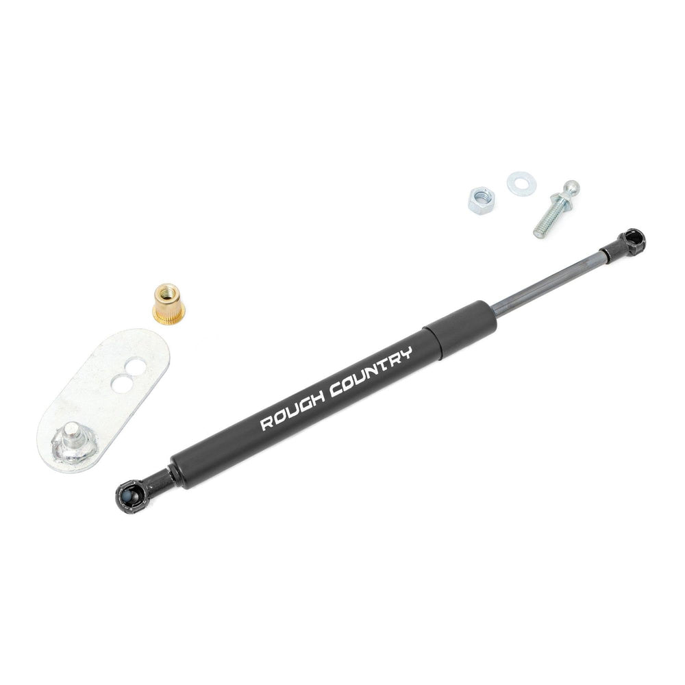 Rough Country assist next to tape measure, shows compact size and easy fitment