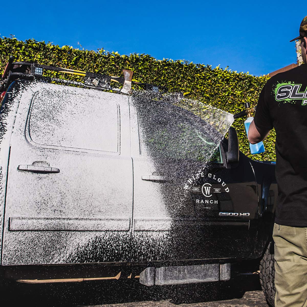 Person using Slick Products washing a car in a driveway for maintenance