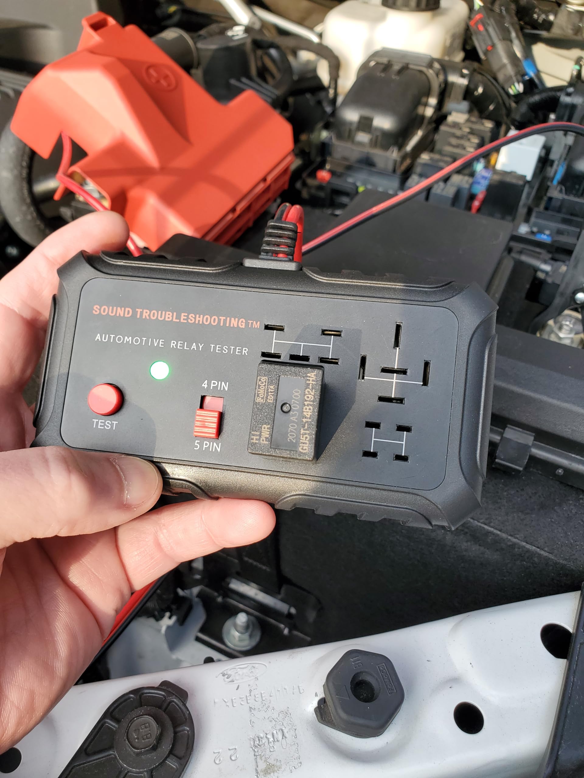 Sound Troubleshooting tester held next to a hand to show compact size and portability