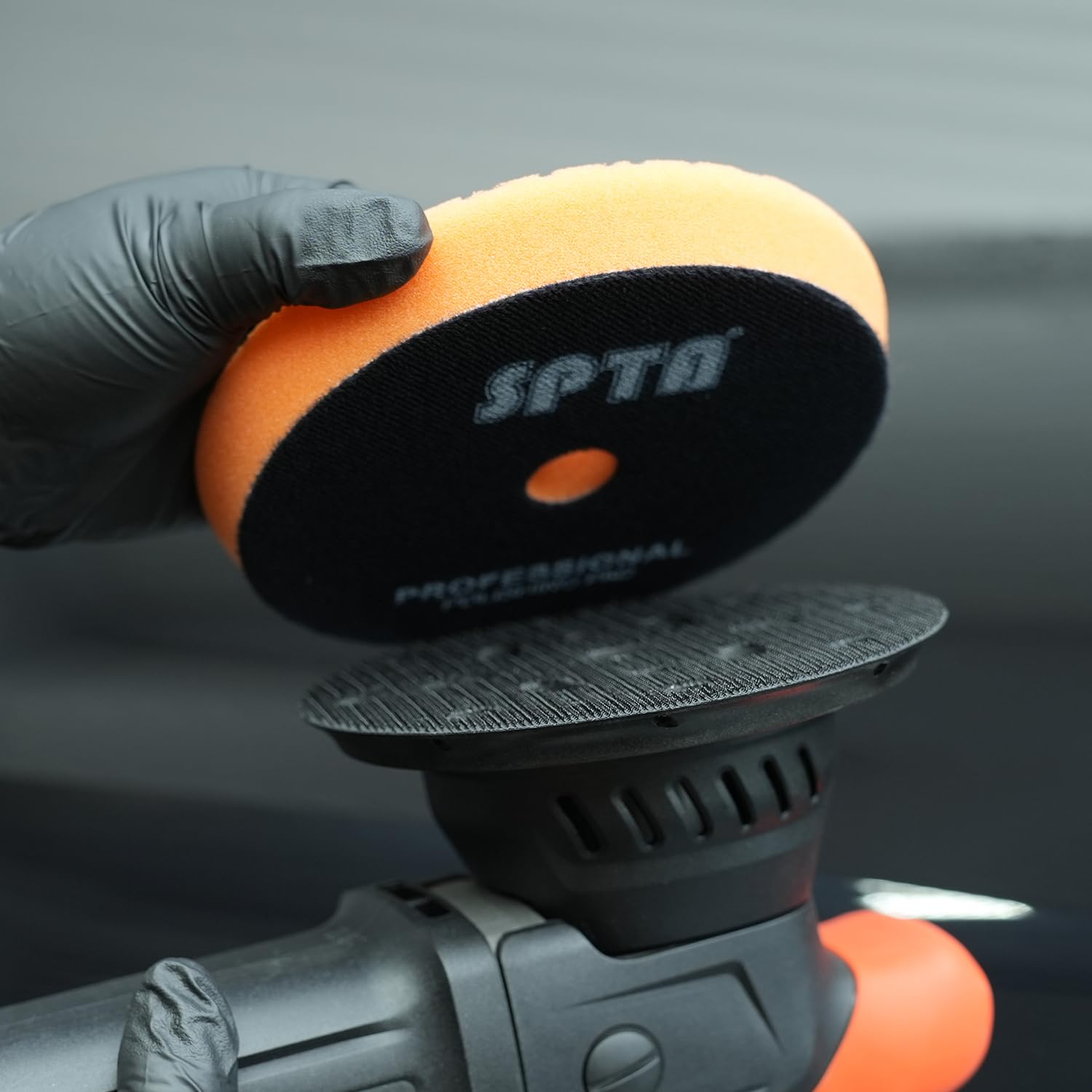 SPTA backing plate attached to foam pad in use for efficient sanding and polishing on vehicle paint