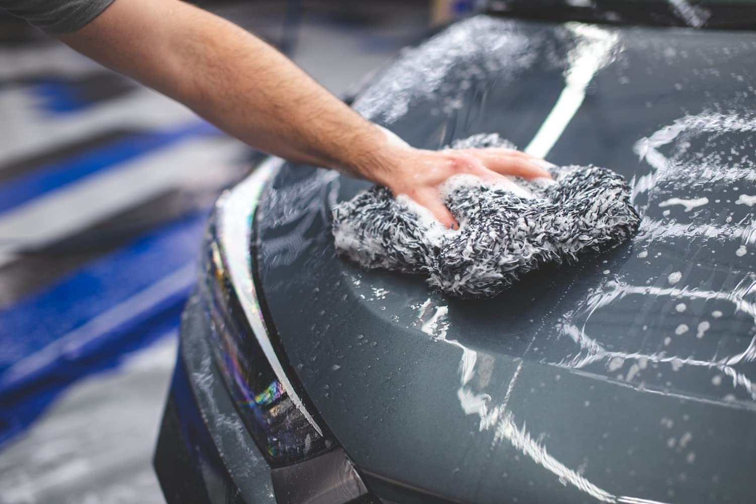 The Rag Company mitt gently gliding on car door showing scratch-free cleaning benefit