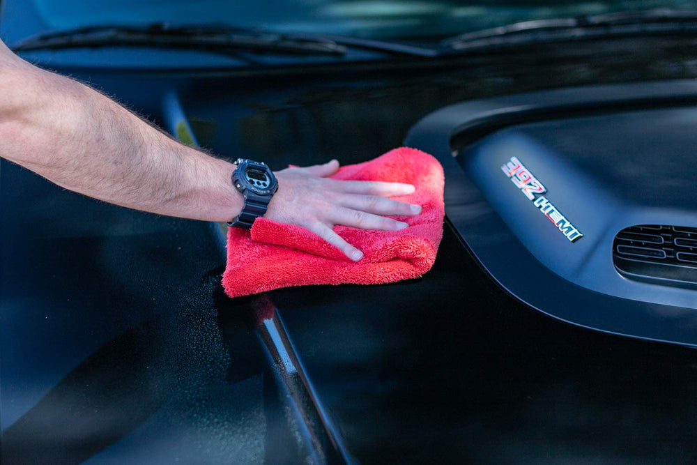 The Rag Company towel next to a hand for scale, compact and precise handling