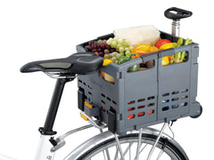 Topeak TrolleyTote carrying groceries beside a bicycle in urban shopping setting