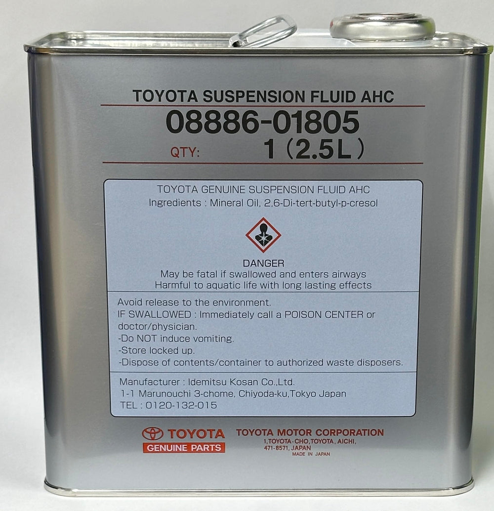 Toyota genuine suspension fluid being poured beside a measured container to ensure correct service volume