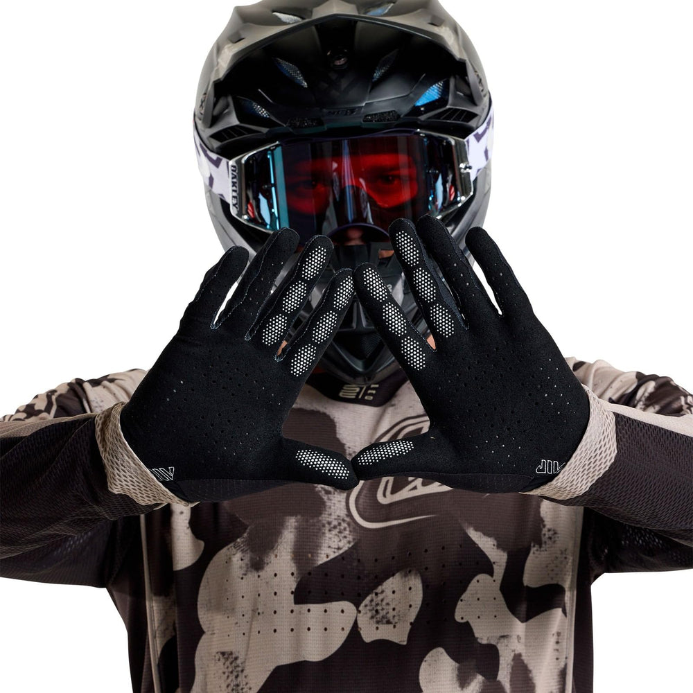 Rider wearing Troy Lee Designs Air Glove using motorcycle handlebar, improving grip and control