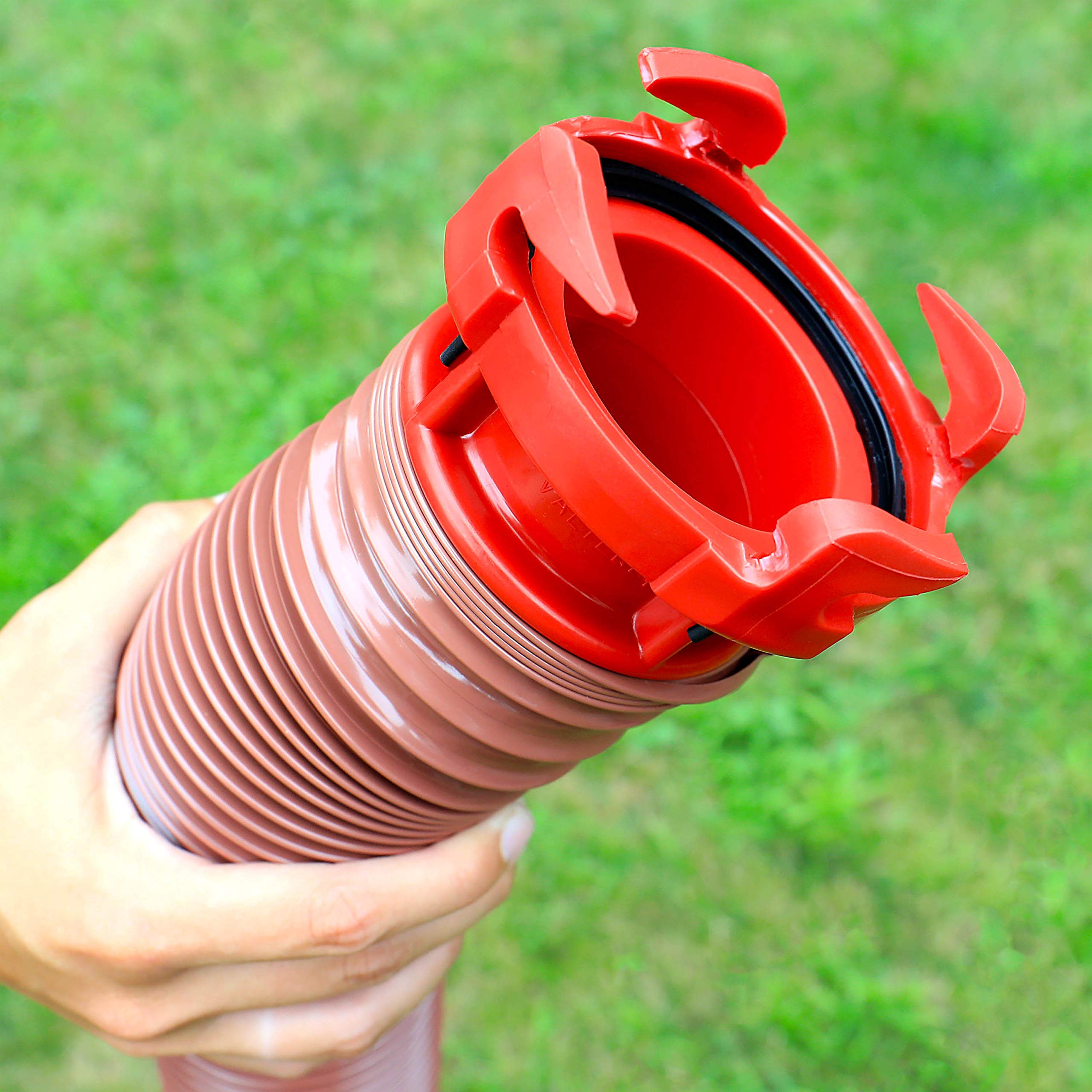 Valterra adapter beside a hand for scale showing small, portable size benefit