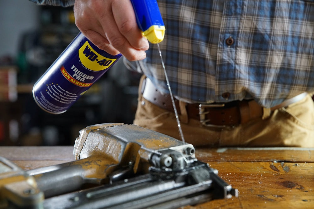 WD-40 Trigger Pro nozzle spraying lubricant onto hinge demonstrating controlled coverage
