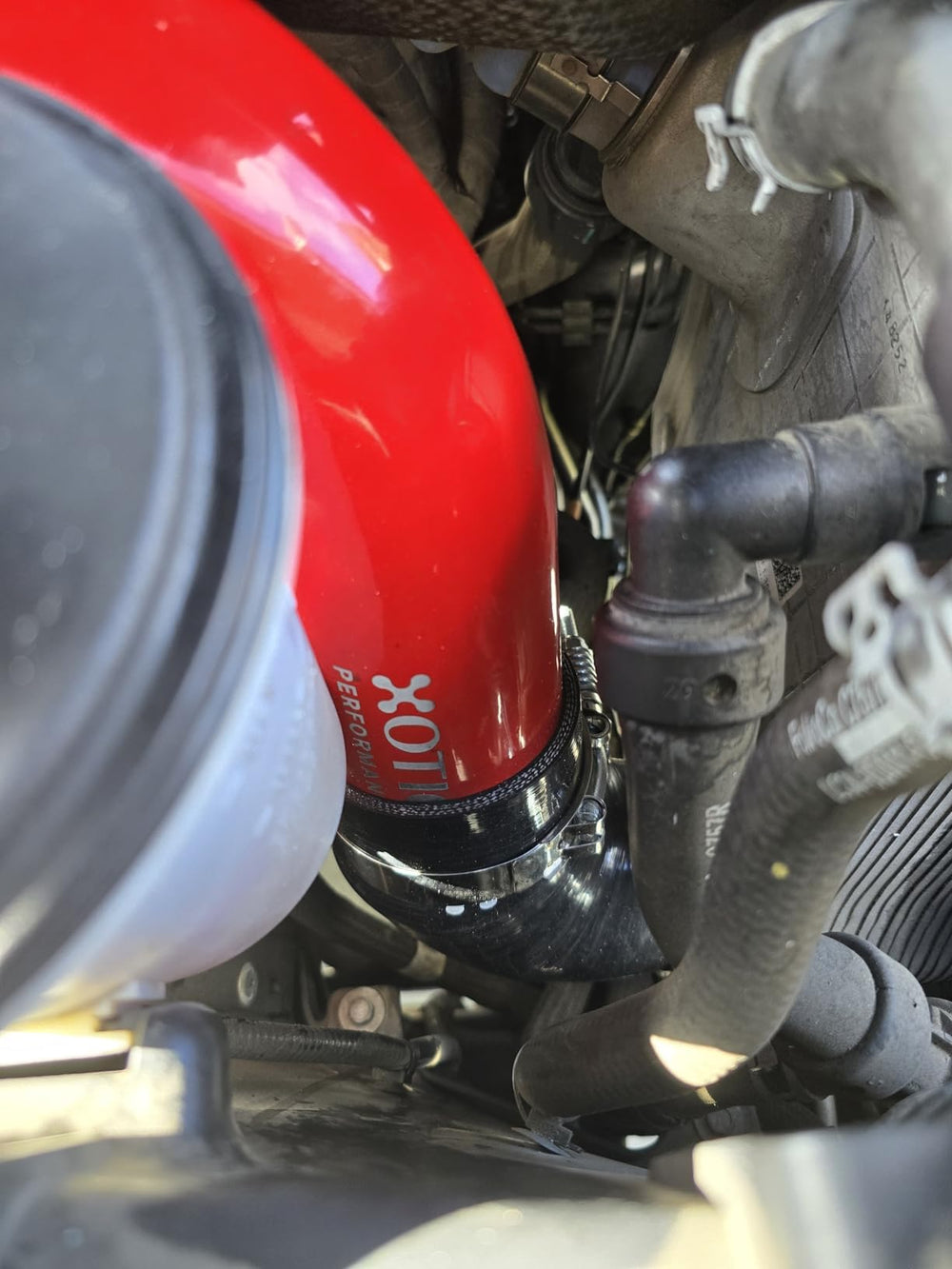 Xotic Performance stainless steel spring-loaded T-bolt clamp closeup showing secure, temperature-adaptive clamp